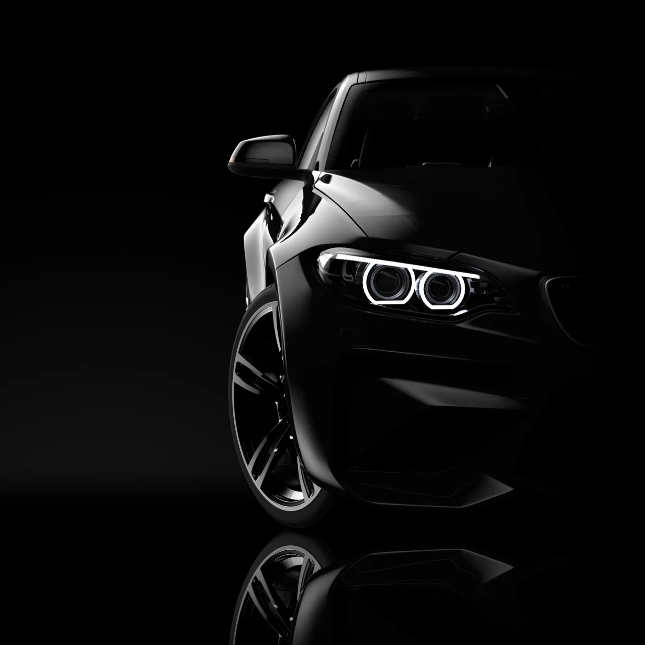 Black car illuminated against a dark background